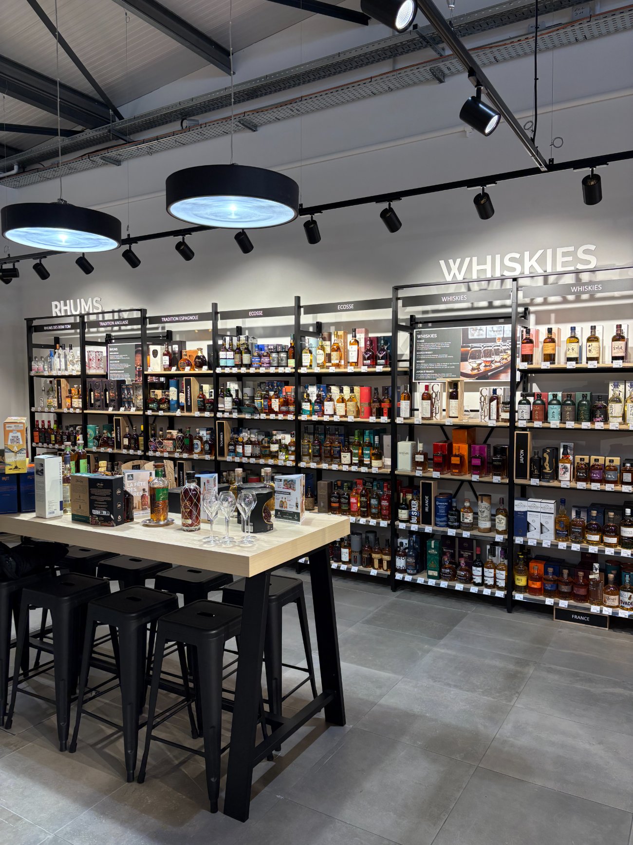Le rayon spiritueux d'Intercaves Villerest — whiskies, rhums et table de dégustation