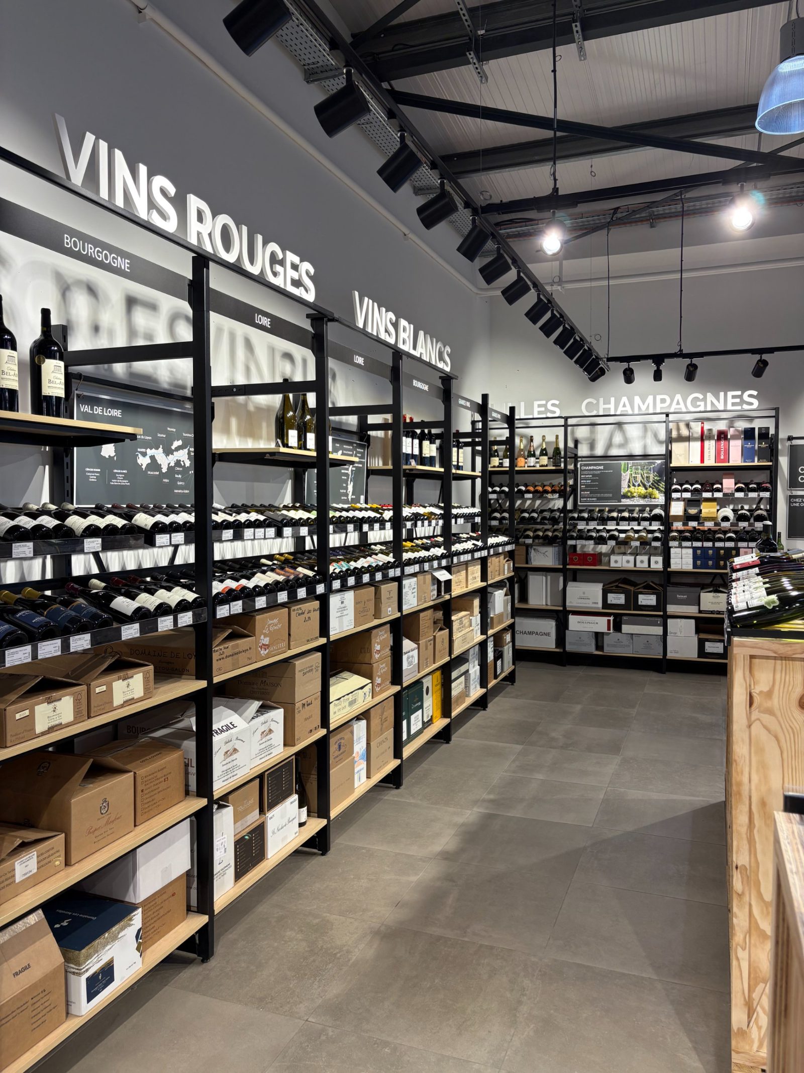 L'intérieur de la cave Intercaves Villerest — rayons vins, champagnes et présentoir central